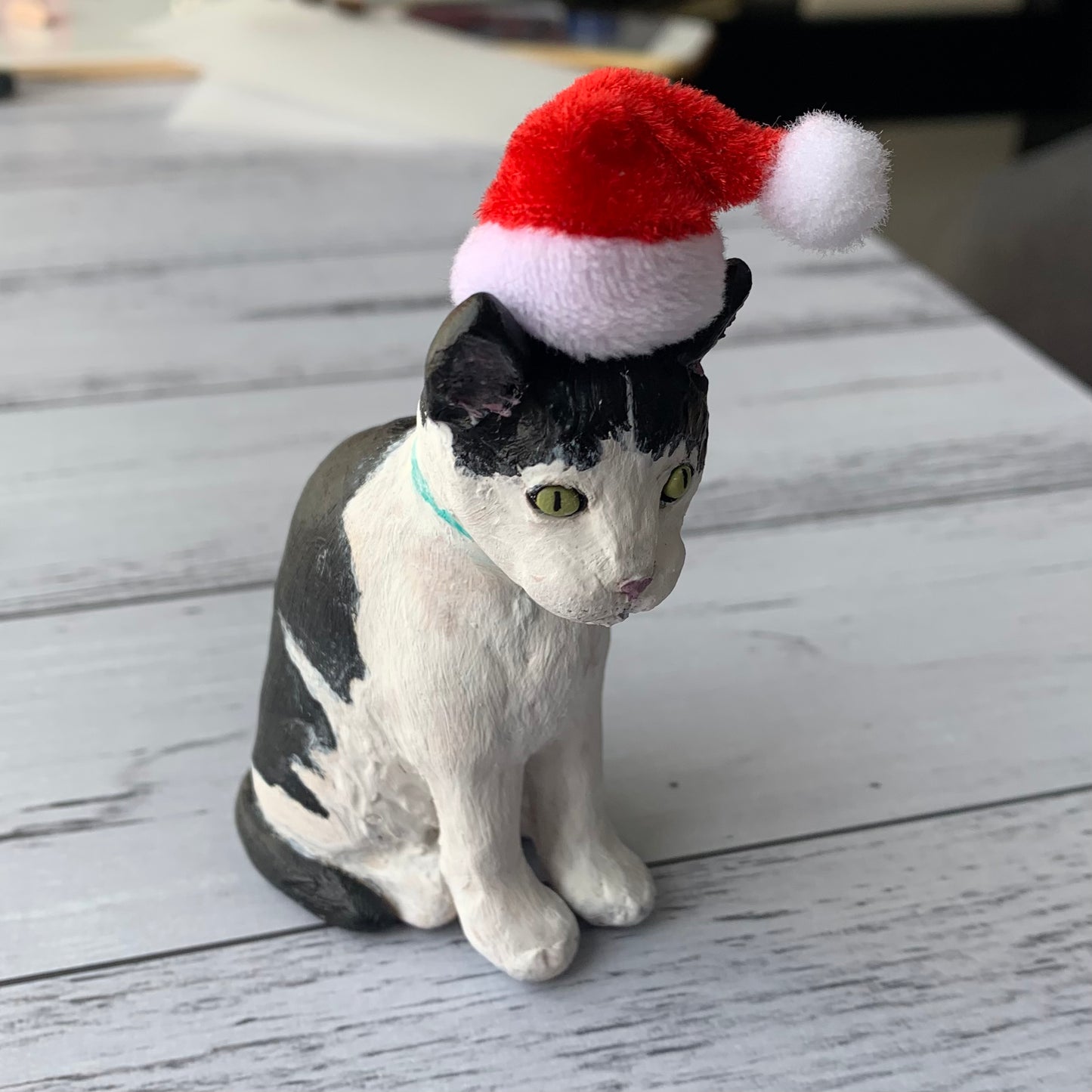 Handmade custom black and white cat figurine wearing santa hat