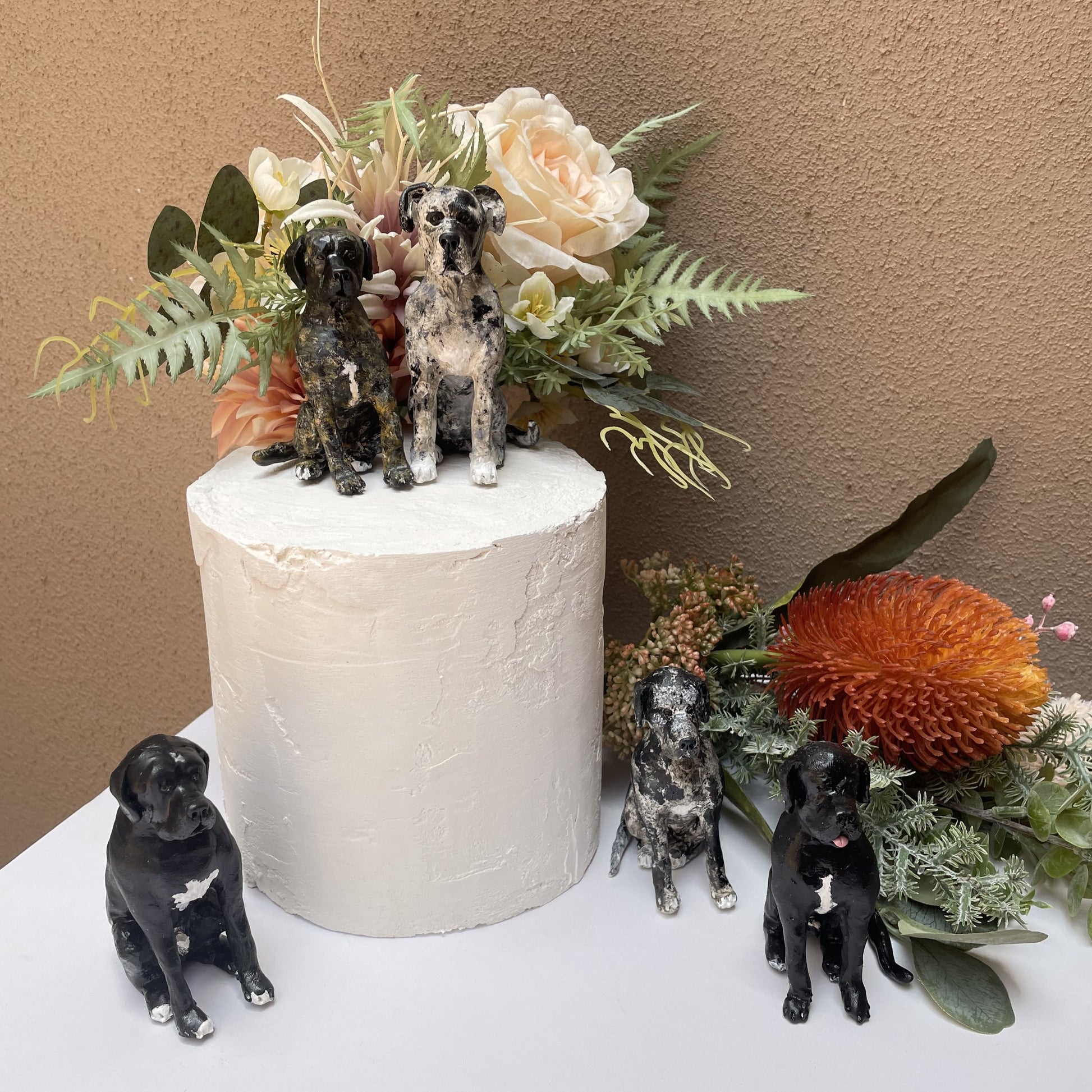 5 bull mastiff wedding cake toppers on dummy cake with flowers