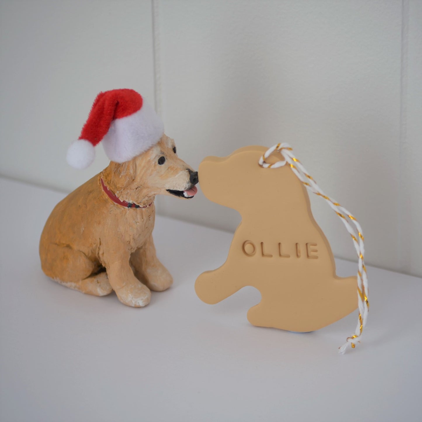 Handmade custom golden retriever dog figurine with santa hat next to pet name christmas ornament