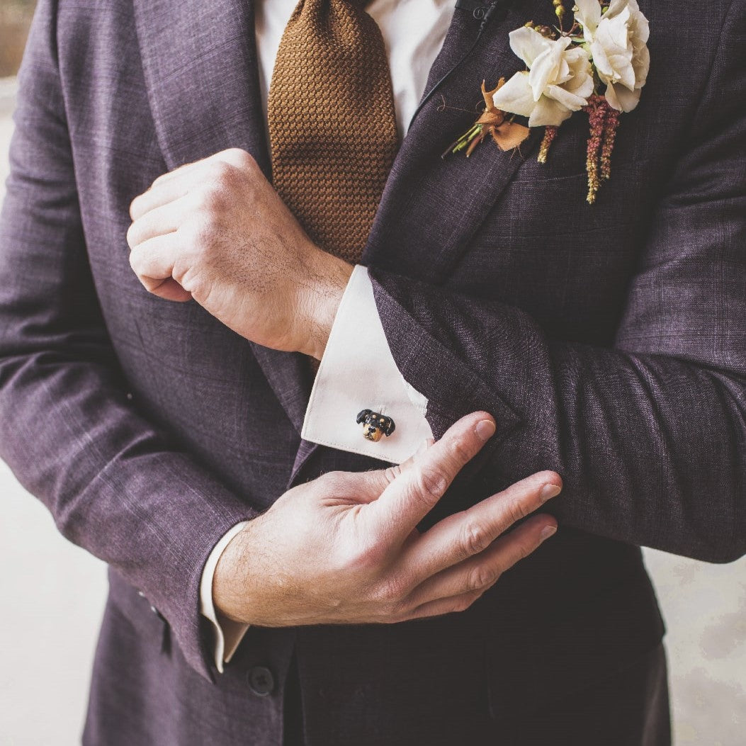Custom dog cufflink shown being worn by a groom in a navy suit