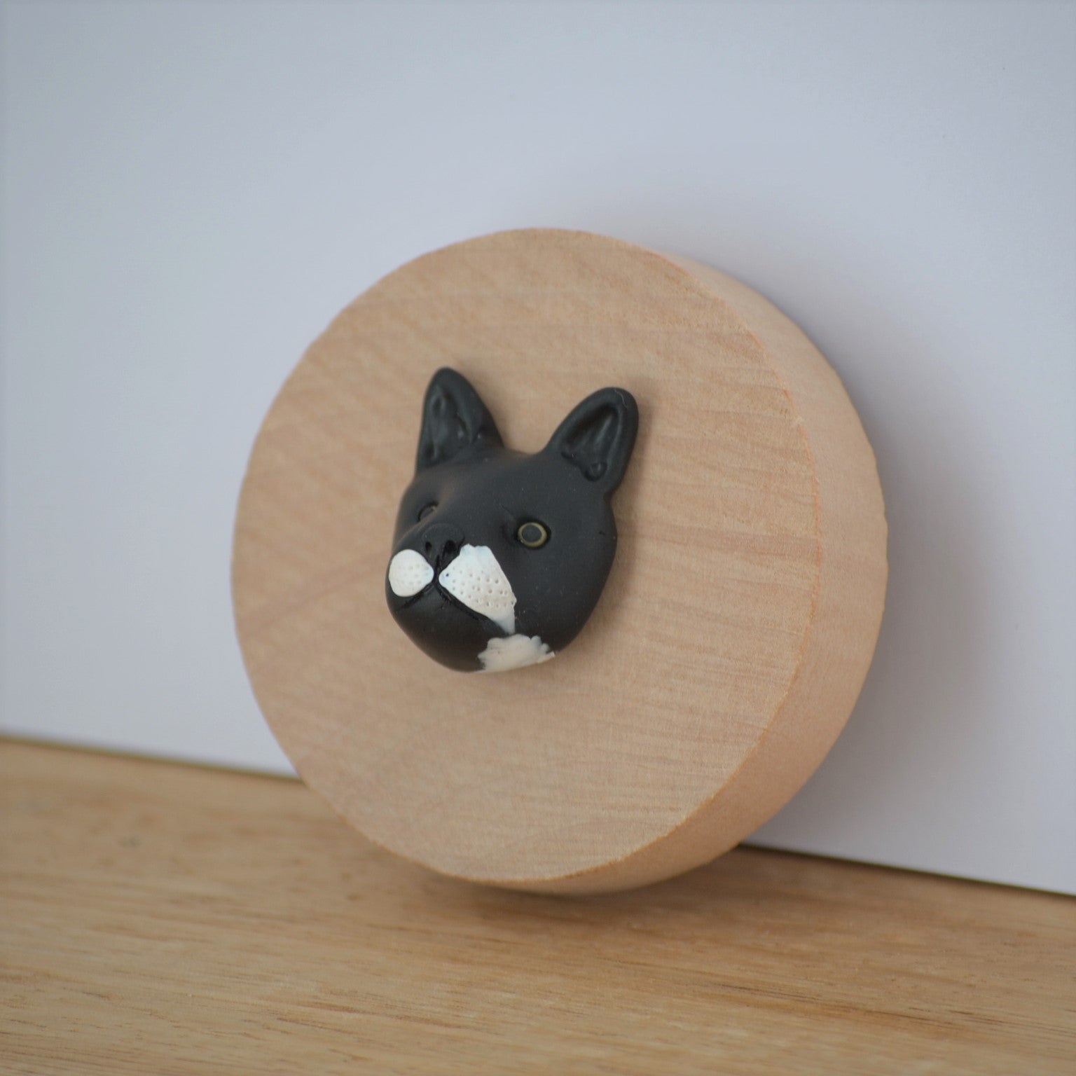 Bottle opener with custom black cat face sculpture attached