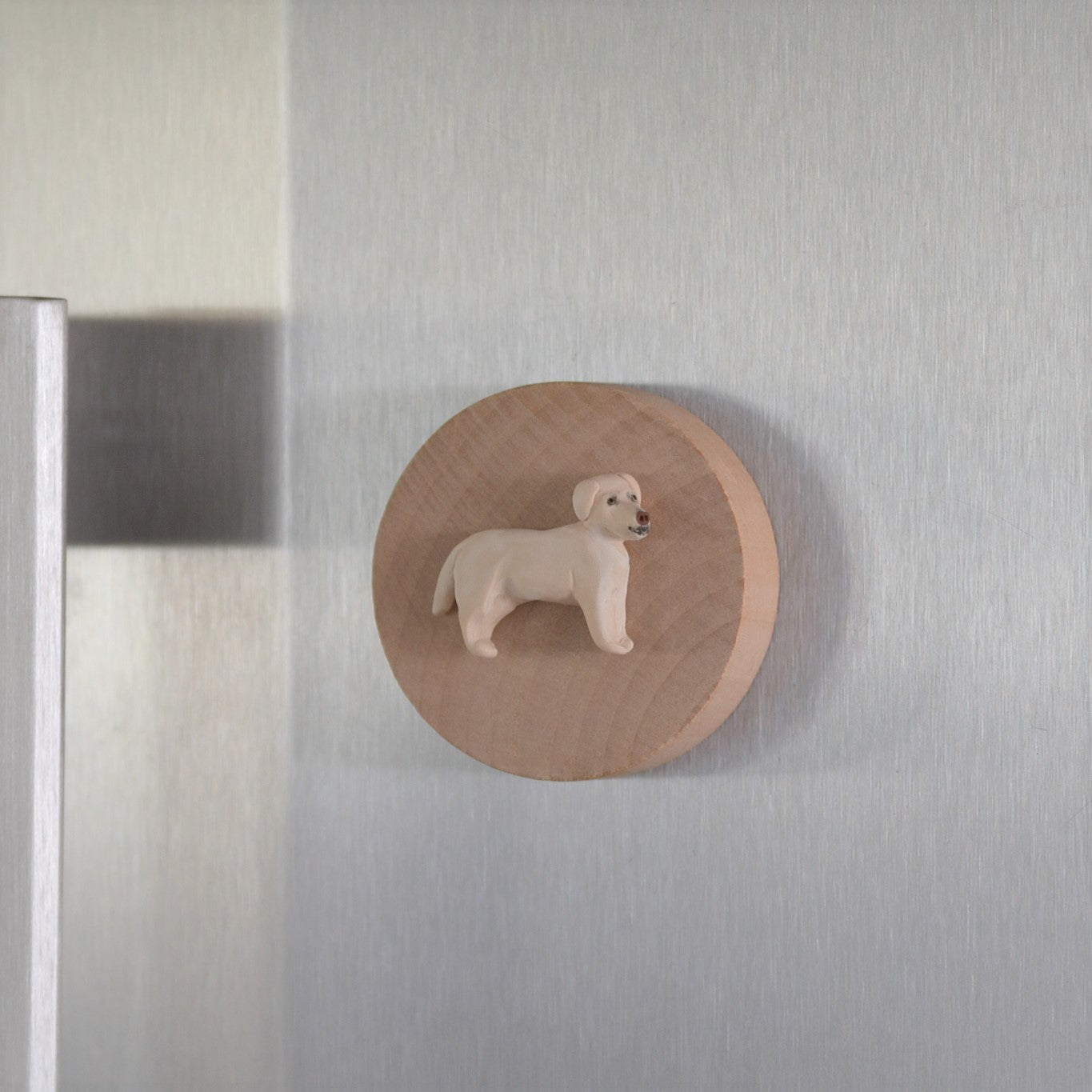 Timber bottle opener with handmade clay yellow lab sculpture attached displayed on fridge