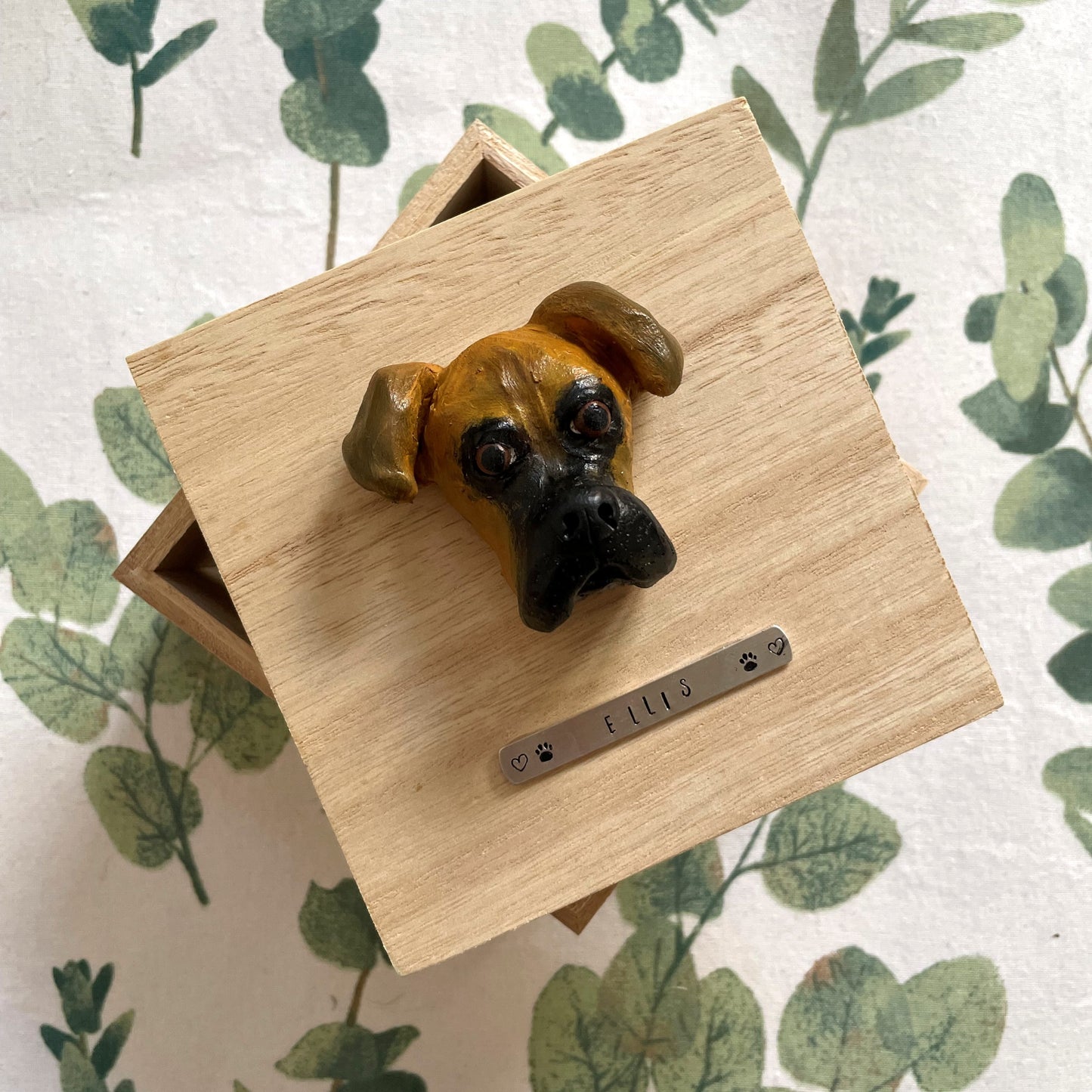 Custom timber pet memorial keepsake box with handscultped dog face on the lid, with a name plaque reading Ellis.