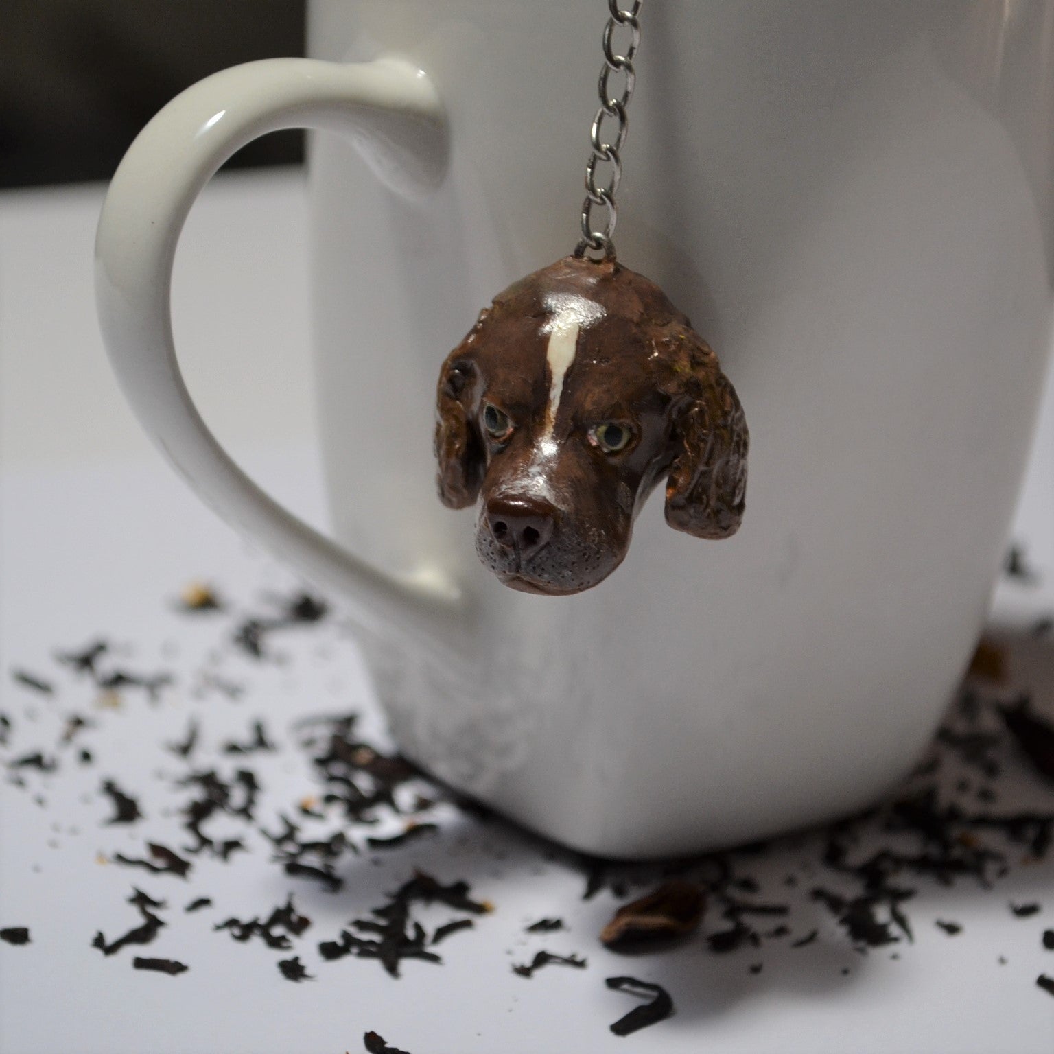Custom dog handmade mesh ball tea strainer in use on a white mug
