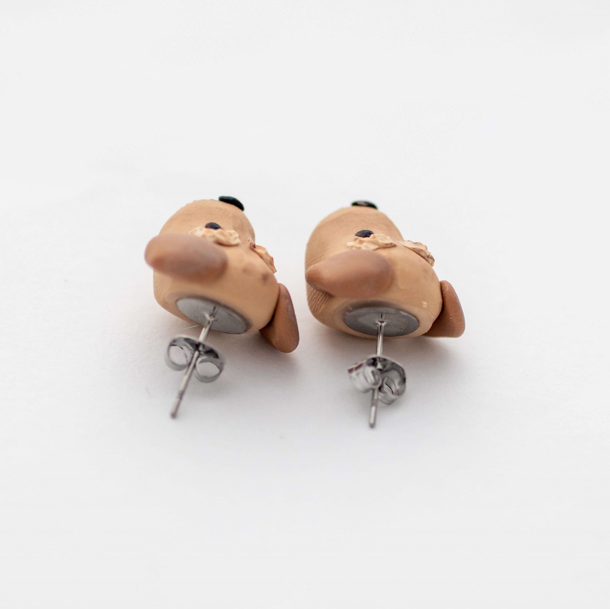 Handmade polymer clay golden retriever dog stud earrings showing surgical steel backs