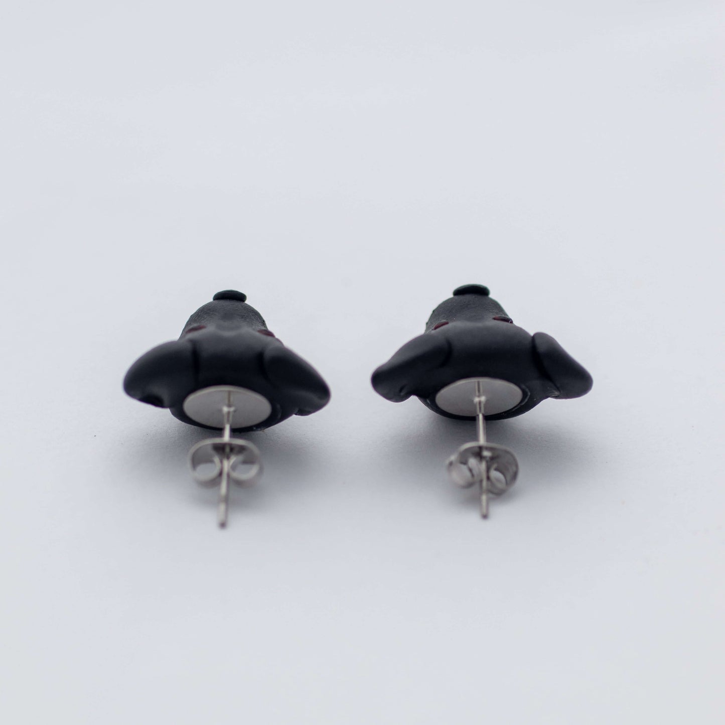 Handmade polymer clay black lab stud earrings showing surgical steel backs