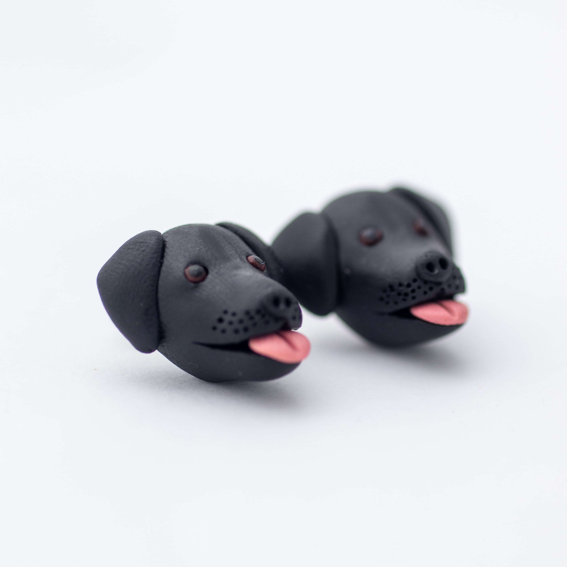 Handmade polymer clay black lab stud earrings up close