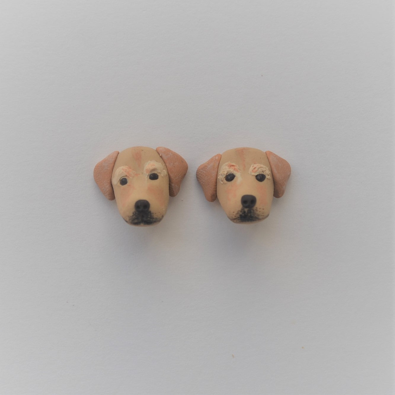 Handmade polymer clay golden lab retriever stud earrings shown on white background