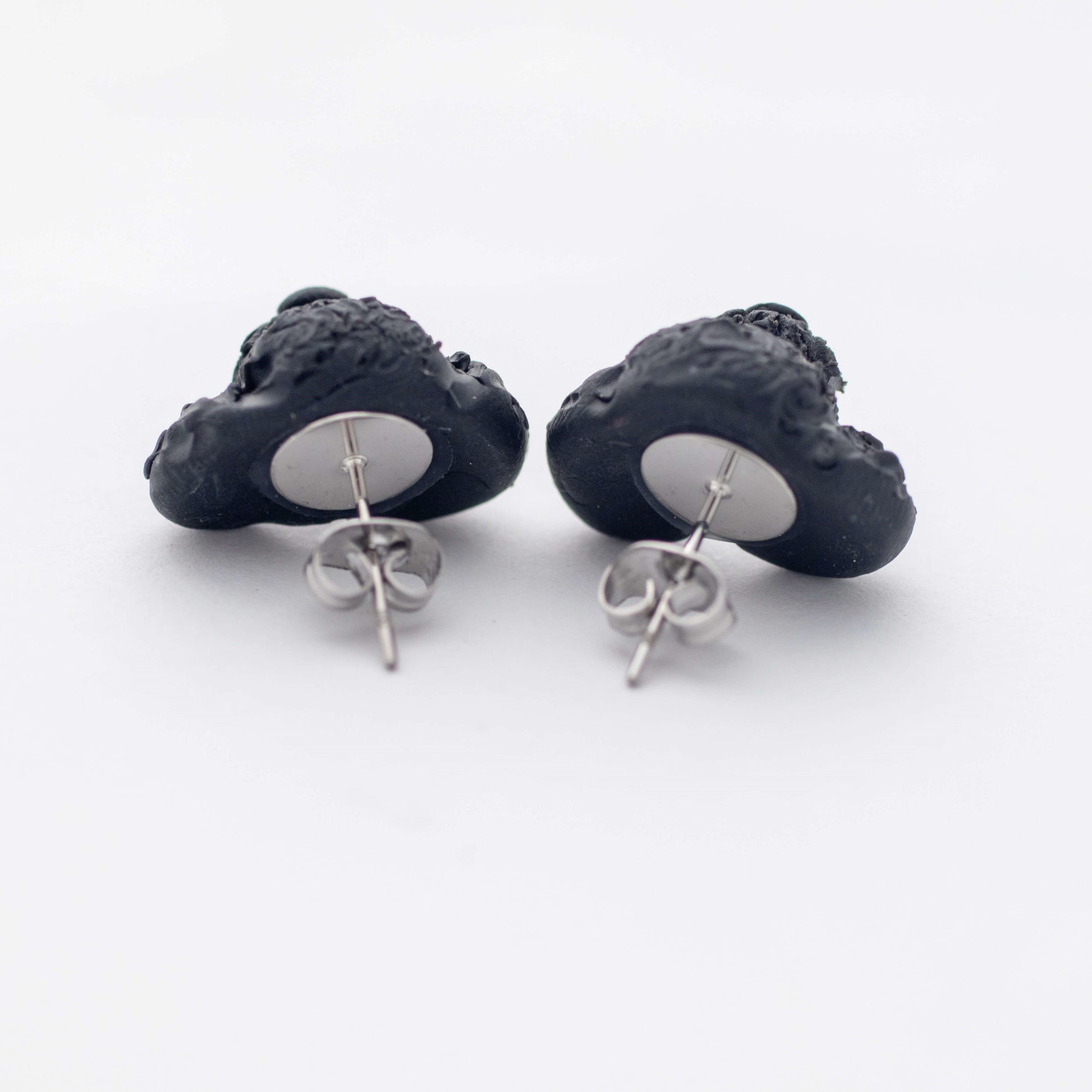Handmade polymer clay black poodle stud earrings showing surgical steel backs