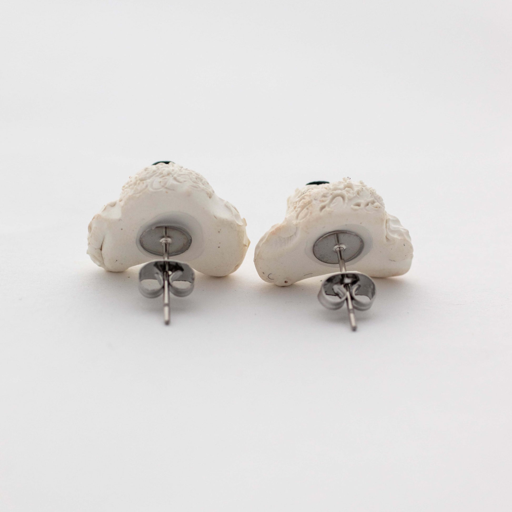 Handmade polymer clay white poodle stud earrings showing surgical steel backs