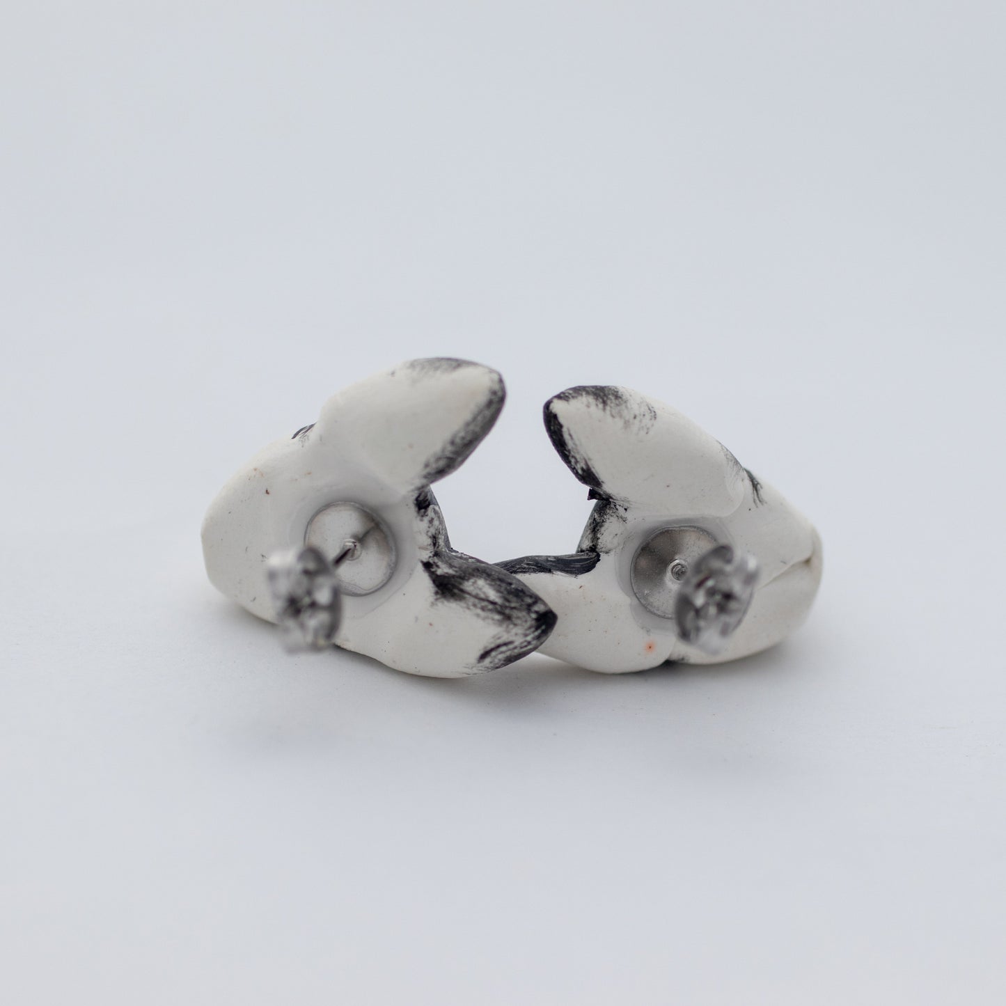 Handmade polymer clay husky stud earrings showing surgical steel backs