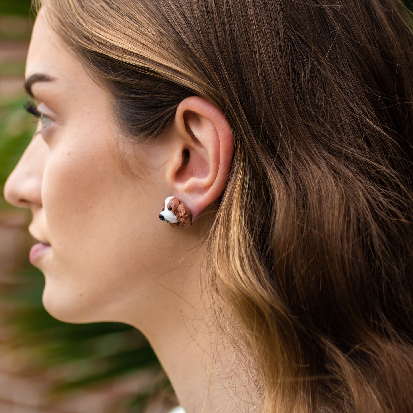 Handmade polymer clay cavalier king charles spaniel stud earrings shown on model's ear