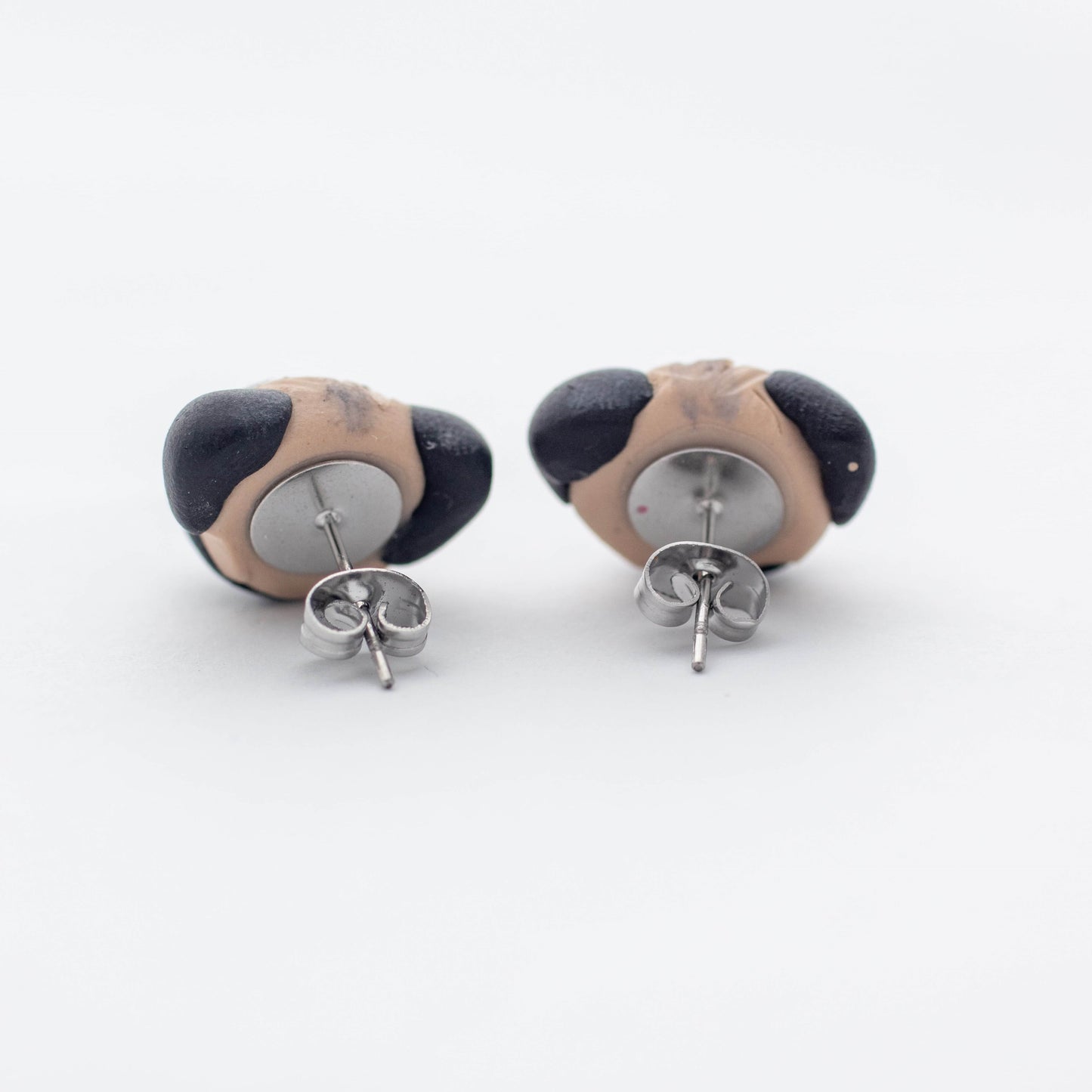 Handmade polymer clay pug stud earrings showing surgical steel backs