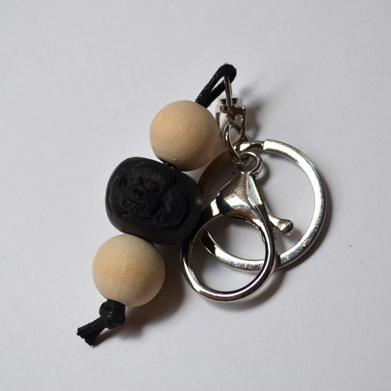 Handmade timber and polymer clay black poodle keychain on a white background.