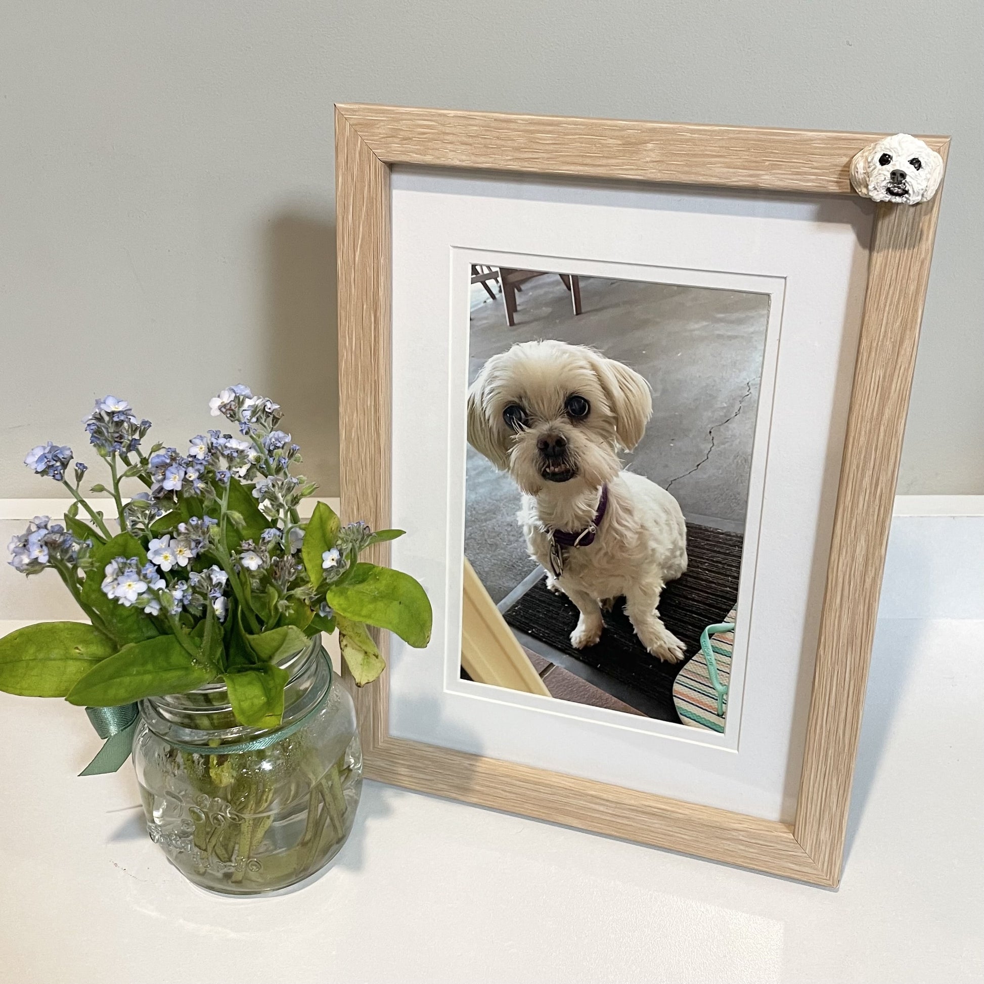 Custom handmade pet photo frames, both in oak colour with a white dog's face.