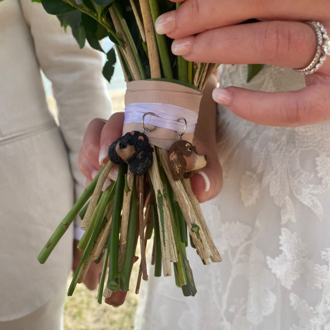 Custom pet bridal bouquet charm photo from a wedding day, featuring 2 dachshund faces..